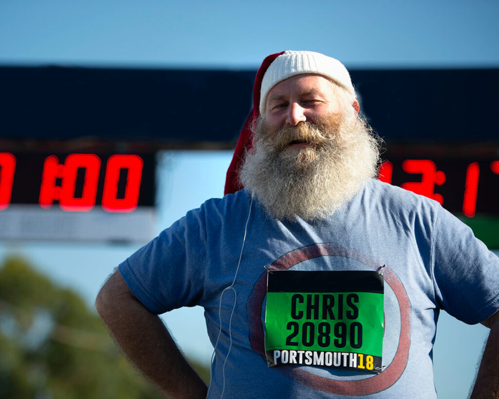 Runner in santa hat stands at start line